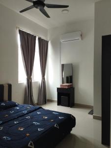 a bedroom with a bed and a ceiling fan at Desaru coast Waterpark and Beach in Desaru