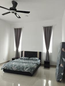 una camera con letto e ventilatore a soffitto di Desaru coast Waterpark and Beach a Desaru