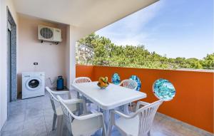 comedor con mesa blanca y sillas en Cozy Apartment In Bibione With Outdoor Swimming Pool, en Bibione