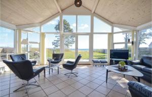 sala de estar con sofá, sillas y TV en Pet Friendly Home In Ebeltoft With House Sea View en Femmøller