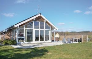 a house with a conservatory on a field at Pet Friendly Home In Ebeltoft With House Sea View in Femmøller