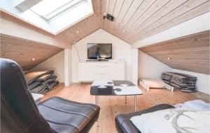 Habitación con sofá, mesa y TV. en Pet Friendly Home In Ebeltoft With House Sea View en Femmøller