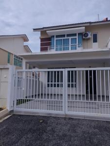 a white fence in front of a house at Desaru coast Waterpark and Beach in Desaru