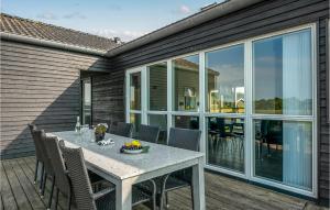 4 Bedroom Beautiful Home In Haderslev في Årø: غرفة طعام مع طاولة وكراسي على السطح