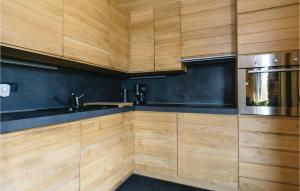 eine Küche mit Holzschränken und einer Mikrowelle in der Unterkunft Beautiful Home In Gornji Zvecaj With Sauna in Gornji Zvečaj