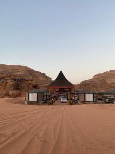 une voiture garée sous un pavillon dans le désert dans l'établissement Wadi Rum Khalid luxury camp, à Wadi Rum