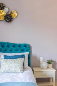 ein Schlafzimmer mit einem blauen Kopfteil und einem Bett mit einem Nachttisch in der Unterkunft Anna Studio in Ammoudara