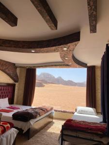 een slaapkamer met 2 bedden en uitzicht op de woestijn bij Wadi Rum Khalid luxury camp in Wadi Rum