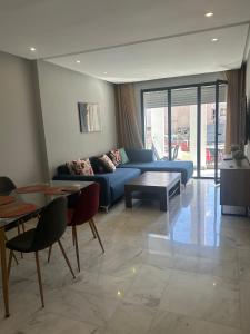 a living room with a blue couch and a table at Twin Center Oasis - Luxury Apartment with Free Parking in Casablanca