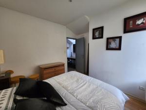 Schlafzimmer mit einem weißen Bett und einem Holztisch in der Unterkunft Le Phisan in Épinal