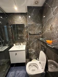 a bathroom with a white toilet and a sink at Twin Center Oasis - Luxury Apartment with Free Parking in Casablanca