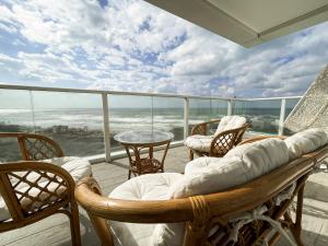 a balcony with chairs and a couch and a table at Sea Resort in H̱adera