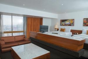 Habitación de hotel con cama, sofá y TV en Sevilla Palace, en Ciudad de México
