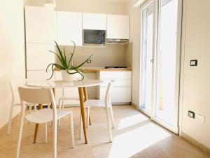 a kitchen with a white table and chairs and a table at Suite Claudia in Sirmione