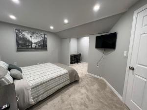 een slaapkamer met een bed en een flatscreen-tv bij Hestia Unit in Kitchener