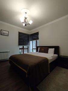 a bedroom with a large bed and a ceiling fan at Qusar Qala Hotel in Qusar