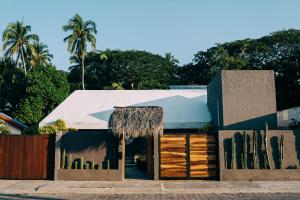 un edificio con techo de paja y valla en Casa Sirena en Ixtapa