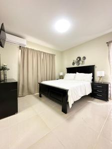 a bedroom with a large bed with white sheets at Lirmar Apartments in Kralendijk