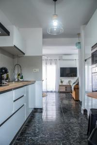 cocina con armarios blancos y suelo de baldosa negra en Apartamentos MC centro, en Ronda