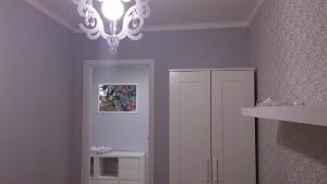 a room with a chandelier and a white cabinet at 1 Bedroom City Center Apartment in Katowice