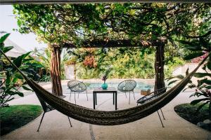a hammock in a garden with a table and chairs at Casa Sirena in Ixtapa