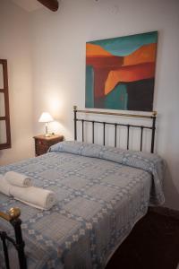 1 cama en un dormitorio con una pintura en la pared en Tampu en Cachí