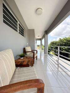 a room with a balcony with a couch and a table at Lirmar Apartments in Kralendijk