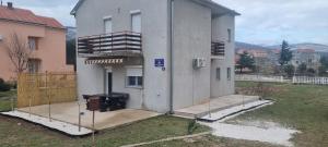 Une maison est en construction avec une terrasse couverte et un balcon. dans l'établissement Kuca za odmor Jozic, à Golubić