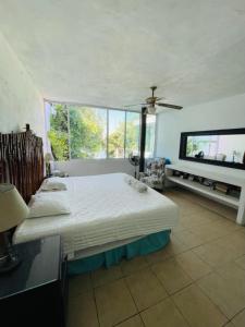 ein Schlafzimmer mit einem großen Bett und einem großen Fenster in der Unterkunft Casa Alfenapa completa para ti y tu familia, pet friendly y a pie del lago in Tequesquitengo