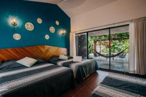 una camera d'albergo con due letti e una finestra di Casa Sirena a Ixtapa Altre 37 foto