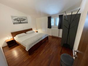 un dormitorio con una cama y un árbol dentro en Apartments Cavar, en Trogir