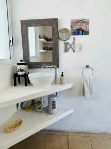 ein Bad mit einem Waschbecken und einem Spiegel in der Unterkunft Casa Alfenapa completa para ti y tu familia, pet friendly y a pie del lago in Tequesquitengo