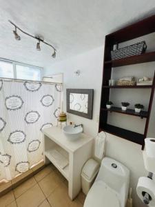 ein weißes Bad mit einem Waschbecken und einem WC in der Unterkunft Casa Alfenapa completa para ti y tu familia, pet friendly y a pie del lago in Tequesquitengo