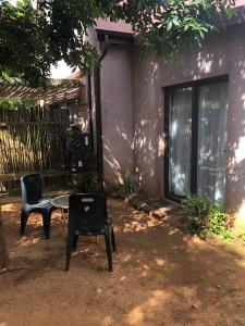 een patio met 2 stoelen en een tafel voor een huis bij Panache in Hoedspruit