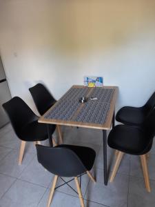 un tavolo di legno con quattro sedie nere intorno di Maza House a Stavros