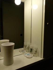 ein Badezimmer mit einer Theke mit einem Spiegel und Pflegeprodukten in der Unterkunft Maza House in Stavros