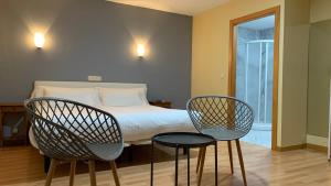 a bedroom with two chairs and a bed and a window at Hotel Posta Real in Sigüenza