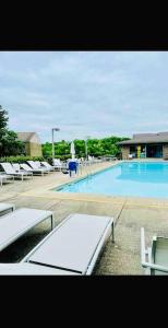 una gran piscina con sillas blancas en HONORAY-Kes, en Monroeville