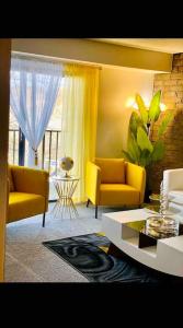 Sala de estar con 2 sillas amarillas y mesa en HONORAY-Kes, en Monroeville