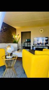 sala de estar con sillas amarillas y mesa en HONORAY-Kes, en Monroeville