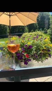a glass of wine sitting on a table with flowers at HONORAY-Kes in Monroeville