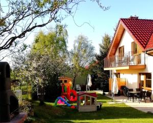 a yard with a playground in front of a house at Promyki - Domy Apartamentowe in Chłopy