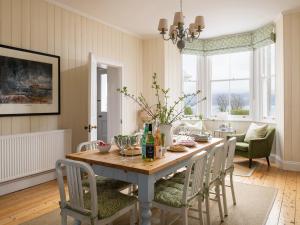 a dining room with a wooden table and chairs at Flagstaff in Beaumaris