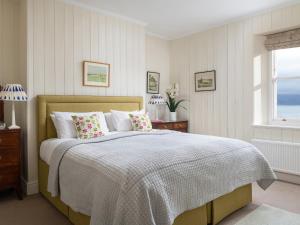 a bedroom with a bed and a window at Flagstaff in Beaumaris