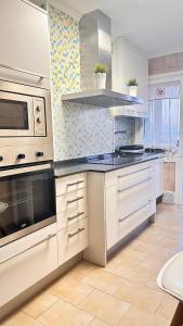 a kitchen with white cabinets and a stove top oven at TUDELA CENTRO-Teatro Gaztambide-3 habitac. in Tudela