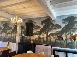 a dining room with a mural of trees on the wall at B&B Château de Fajac la Selve in Pech-Luna