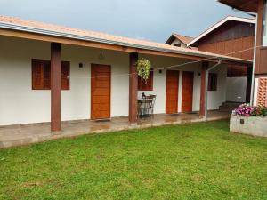 蒙特韦尔迪Chalé dos Pellizzari的一座带橙色门和绿色庭院的房子