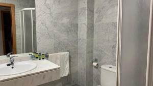 Hotel Posta Real في سيغوينزا: حمام مع حوض ومرحاض ومرآة