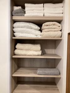 un armario lleno de toallas blancas en Midrahov Luxury Apartment en Zikhron Ya‘aqov