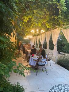 een groep mensen die aan een tafel op een patio zitten bij B&B Château de Fajac la Selve in Pech-Luna